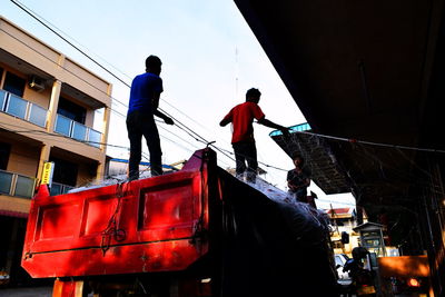 Rear view of people working against sky