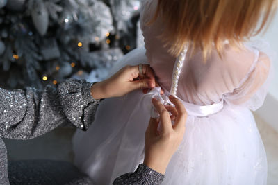 Midsection of bride holding wedding dress