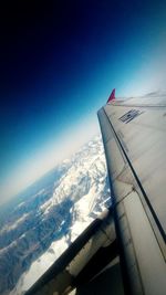 Cropped image of airplane flying over mountain