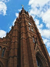 Low angle view of building against cloudy sky