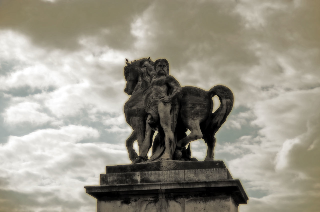 LOW ANGLE VIEW OF STATUE OF LION AGAINST CLOUDY SKY