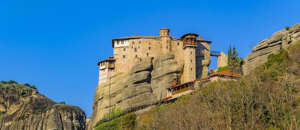 Low angle view of old ruins against clear blue sky