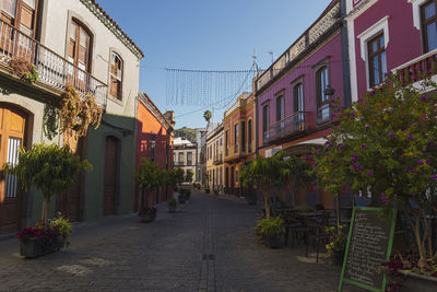 Street amidst houses and buildings against sky