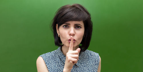 Portrait of beautiful young woman over green background