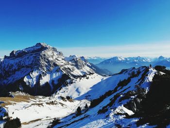 Scenic view of snowcapped mountains against clear blue sky