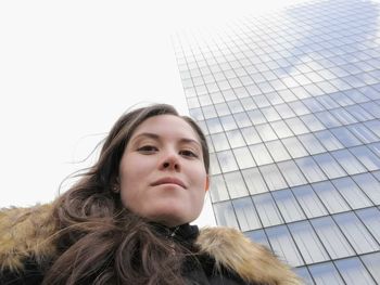 Portrait of beautiful young woman against sky