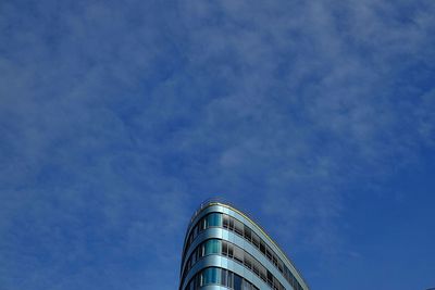 Low angle view of modern building against cloudy sky