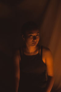 Portrait of beautiful young woman against black background