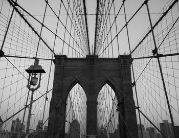 Low angle view of suspension bridge against sky