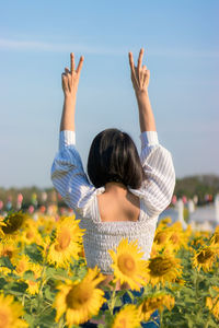 Rear view of woman standing on field