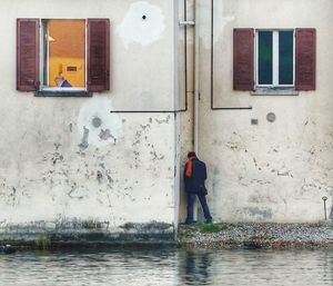 Reflection of man on wet window in building