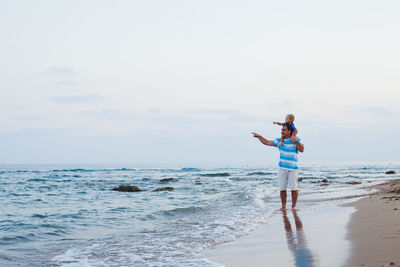 Man standing on beach against sky