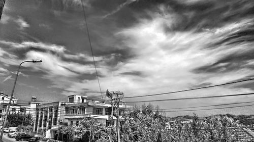 Power lines against cloudy sky