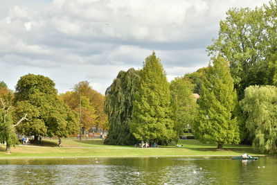 Scenic view of trees by lake against sky
