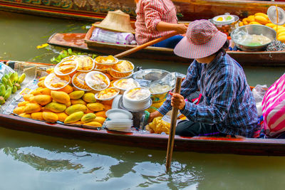 High angle view of woman selling fruits in floating market