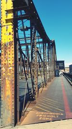 Metal bridge against sky in city