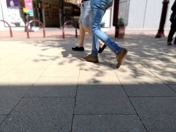 Low section of person walking on sidewalk