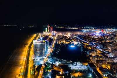 High angle view of illuminated city against sky at night