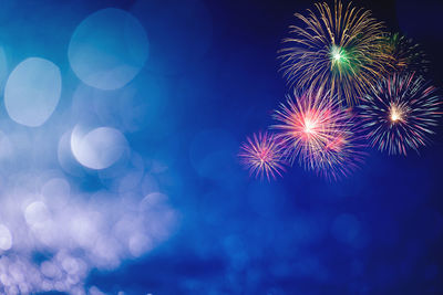Low angle view of firework display at night