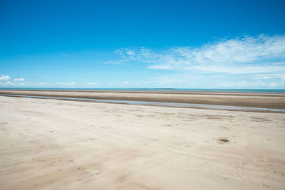 Scenic view of beach against blue sky