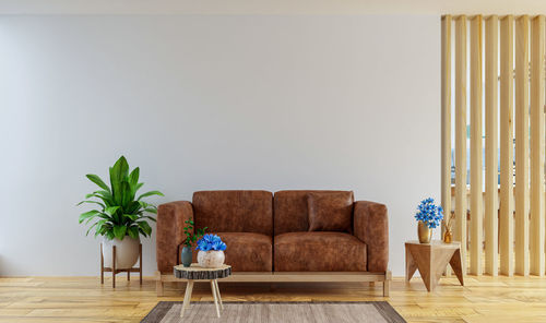 Living room interior wall mockup in warm tones with leather sofa which is behind the kitchen.