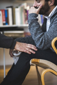 Cropped image of doctor touching depressed patient during session