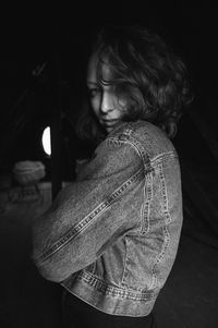 Portrait of young woman standing in darkroom