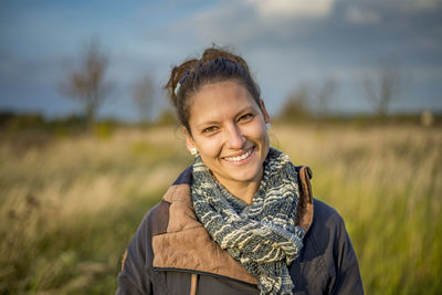 Portrait of smiling young woman standing on field