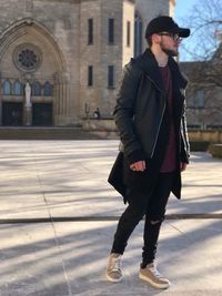 Full length of young man standing against building