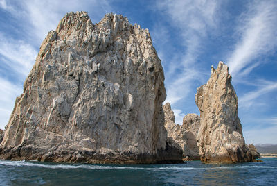 Rock formation in sea against sky