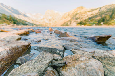 Close-up of rocks in a lake and mountain peak on background 