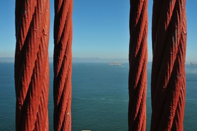 Close-up of red golden gate bridge steel cables against san francisco bay