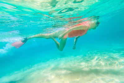 Low angle view of young woman swimming in sea