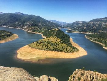 Scenic view of lake and mountains against clear sky