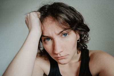 Close-up portrait of sulking young woman at home