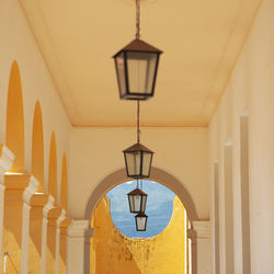 Low angle view of illuminated pendant lights hanging in building