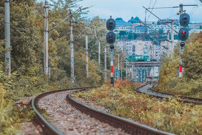 Curving railways with traffic lights during autumn season with buildings in the distance