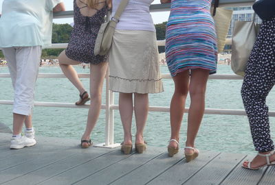 Low section of people standing on tiled floor