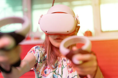 Vr game virtual reality. kid girl gamer playing on futuristic simulation video game in 3d glasses