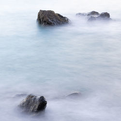 Rocks in sea against sky