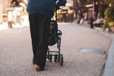 Rear view low section of man walking on road