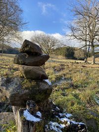 Stack of rocks on field against sky