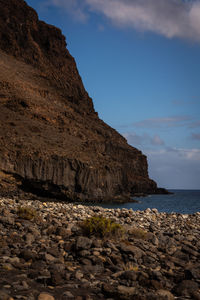 Rock formations by sea against sky