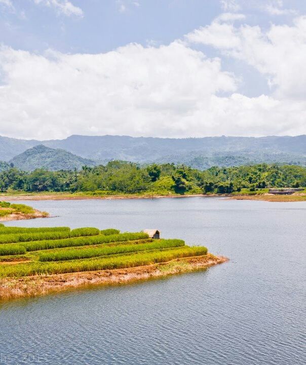 tranquil scene, sky, tranquility, water, scenics, beauty in nature, cloud - sky, landscape, grass, nature, mountain, cloud, lake, green color, cloudy, growth, field, river, plant, idyllic