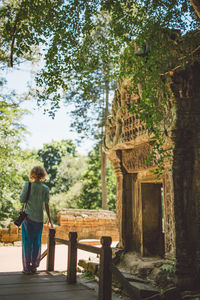 Rear view of woman standing by ancient temple