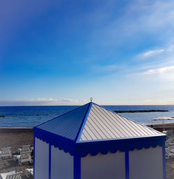 Built structure on beach against blue sky