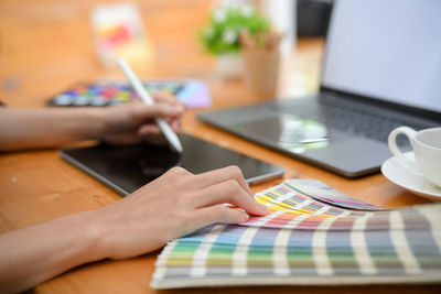 Midsection of woman using laptop on table