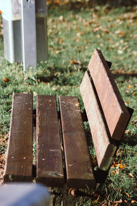 High angle view of wooden bench on field