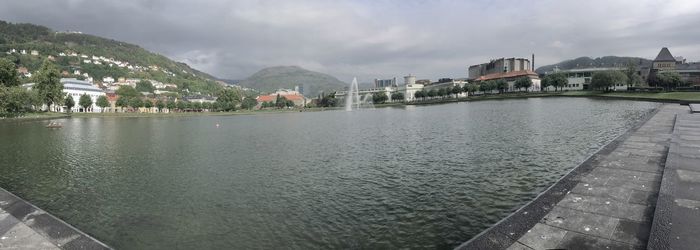 Scenic view of river by buildings against sky