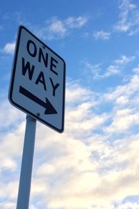 Low angle view of road sign against cloudy sky